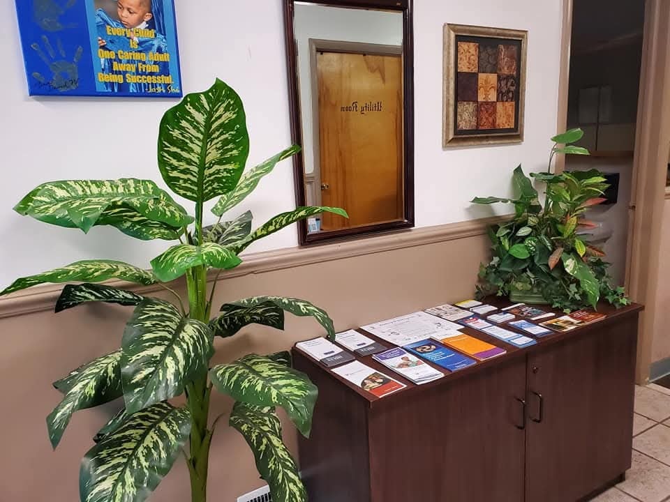 Center lobby with lush plants, resource brochures, and an inspirational wall quote